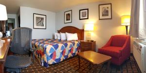 ein Hotelzimmer mit einem Bett und einem Stuhl in der Unterkunft Le Mars Inn and Suites in Le Mars