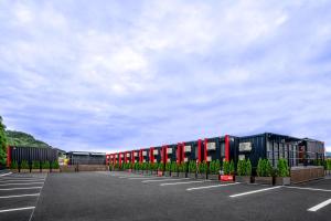 un parking avec une rangée de conteneurs rouges dans l'établissement HOTEL R9 The Yard Kanuma Sakae, à Kanuma