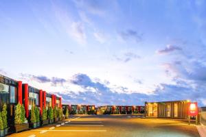 eine Reihe von Gebäuden auf einer Straße mit wolkigem Himmel in der Unterkunft HOTEL R9 The Yard Ashikagafukutomi in Ashikaga