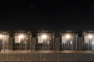 een rij gebouwen met 's nachts verlichting bij HOTEL R9 The Yard Ota in Ota