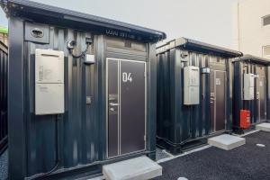 eine Reihe tragbarer Toiletten auf einem Parkplatz in der Unterkunft HOTEL R9 The Yard Togane in Tōgane