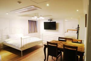 a bedroom with a bed and a table and a crib at Hillside Hotel in Busan