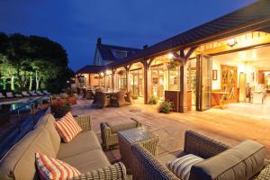 a patio with couches and chairs and a pool at The Farmhouse Hotel and Restaurant in St Saviour Guernsey