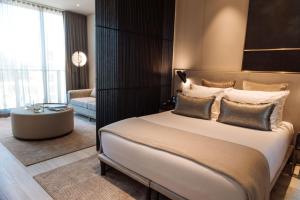 a bedroom with a large bed and a living room at SKYE Suites Green Square in Sydney