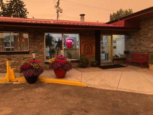 a building with two pots of flowers in front of it at Trailside Inn in Lloydminster