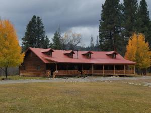 a large wooden cabin with a red roof at The Wild Game Inn in Alta