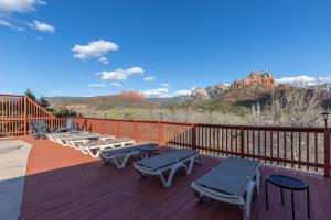 eine Terrasse mit Liegestühlen, Tischen und Bergen in der Unterkunft Cedars Resort in Sedona