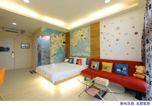高雄的住宿－八五亞太旅店 (亞太投資大樓)，一间卧室配有一张床和一张红色的沙发