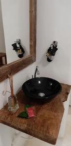 a bathroom with a black sink on a wooden counter at Pousada Amor de Casa in Trancoso