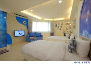 a hotel room with two beds and a flat screen tv at 85 Asia Hotel in Kaohsiung