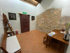 a room with a table and a stone wall at House by the Well 總兵人家 in Jincheng