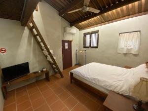 a bedroom with a bed and a staircase in it at House by the Well 總兵人家 in Jincheng