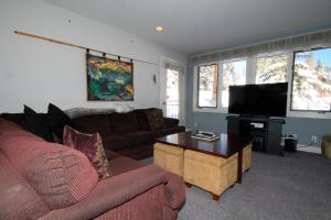 a living room with a couch and a flat screen tv at Mountainback 062 in Mammoth Lakes