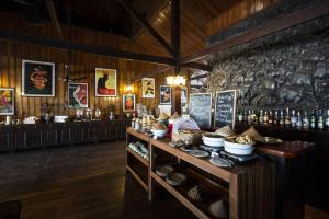 a restaurant with a counter with food on it at La Folie Lodge in Champasak