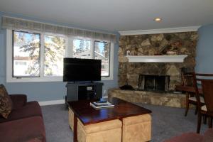 a living room with a tv and a fireplace at Mountainback 062 in Mammoth Lakes