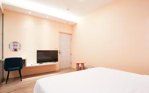 1 dormitorio con 1 cama y TV de pantalla plana en Amethyst Bay Theme HomeStay II, en Magong