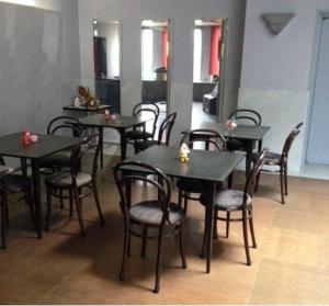 a group of tables and chairs in a restaurant at Narita Airport Samurai Hostel in Kujukuri