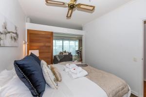 a bedroom with a bed with a ceiling fan at Premium 1BR Apartment at Princes Wharf in Auckland