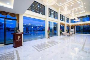 a large lobby with glass windows and a podium at Pura Nakhon Hotel in Nakhon Si Thammarat