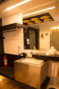 a bathroom with a sink and a large mirror at Canvas Boutique Hotel in Puerto Princesa City