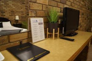a desk with a computer and a monitor on it at Magdala Motor Lodge & Lakeside Restaurant in Stawell