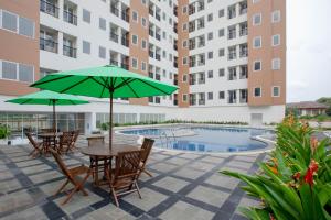 a patio with tables and umbrellas and a pool at Urban Express HomTel - Serpong in Banten