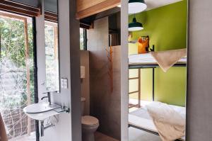a tiny house with a bathroom with a toilet and a sink at Spin Designer Hostel - El Nido in El Nido