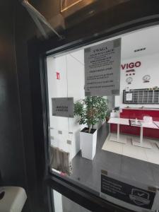 Vigo Hotel في لودز: نافذة من متجر vico مع نبات الفخار