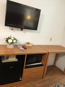 a desk with a television on a wall at OceanView Motel in Huntington Beach