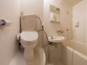 a small bathroom with a toilet and a sink at Tabist Hotel Kurama Hikone in Takamiya