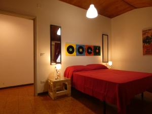 a bedroom with two beds with red sheets and a table at Holiday House in Santa Severina
