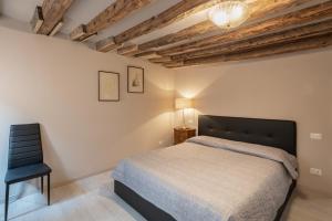 um quarto com uma cama e uma cadeira preta em ANDREA Venice FLAT 3rd Floor em Veneza