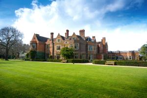 uma casa grande com um relvado verde em frente em Warren House Hotel em Kingston upon Thames