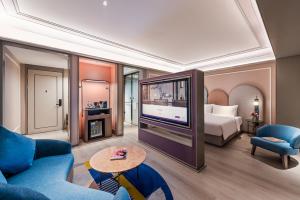 a living room with a television and a bed at Mercure Nanjing Downtown in Nanjing +48 photos