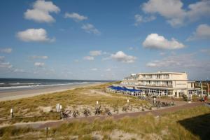 a building on the beach next to a beach at WestCord Strandhotel Seeduyn in Oost-Vlieland