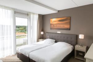 Postel nebo postele na pokoji v ubytování WestCord Strandhotel Seeduyn