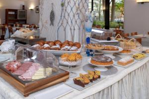 un bufé con diferentes tipos de repostería y postres. en Hotel Morotti, en Misano Adriatico