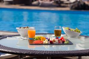 a tray of food and drinks on a table by a pool at Vitalclass Lanzarote Resort in Costa Teguise