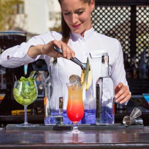 a woman is making a drink in a bartender at Vitalclass Lanzarote Resort in Costa Teguise
