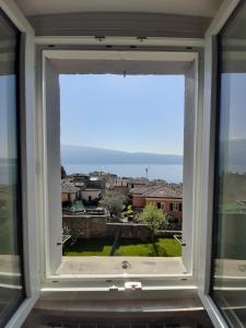 a window with a view of a city at La Petite Maison in Gargnano +10 photos