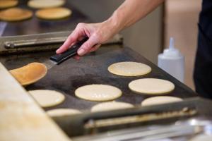 a person is cooking pancakes on a grill at Vitalclass Lanzarote Resort in Costa Teguise