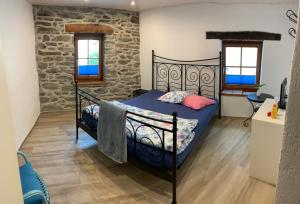 a bedroom with a bed and a stone wall at BnB Cà di sciavatin in San Vittore