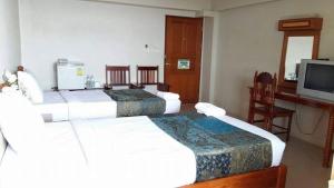 a hotel room with three beds and a television at ทรัพย์มุกดา แกรนด์ โฮเทล Submukda Grand Hotel in Mukdahan