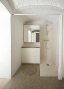 a white bathroom with a sink and a mirror at HÜBSCHES APARTMENT im Herzen von Linz in Linz