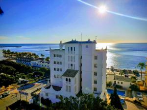 貝納爾馬德納的住宿－陽光海灘酒店，一座白色的建筑,背靠大海