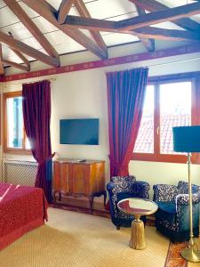 a bedroom with a bed and two chairs and a tv at Hotel La Calcina in Venice