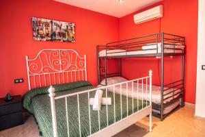 リョレート・デ・マルにあるApartaments Yacoの赤い壁のベッドルーム1室(二段ベッド2組付)