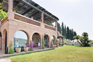 a brick building with potted plants in a yard at Can Borrell Villa Carmen in Castellar