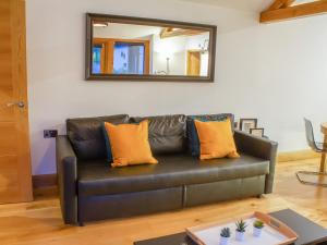 a leather couch in a living room with a mirror at The Oaks in Llangollen