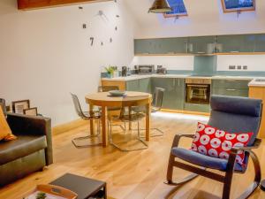 a living room with a table and a kitchen at The Oaks in Llangollen